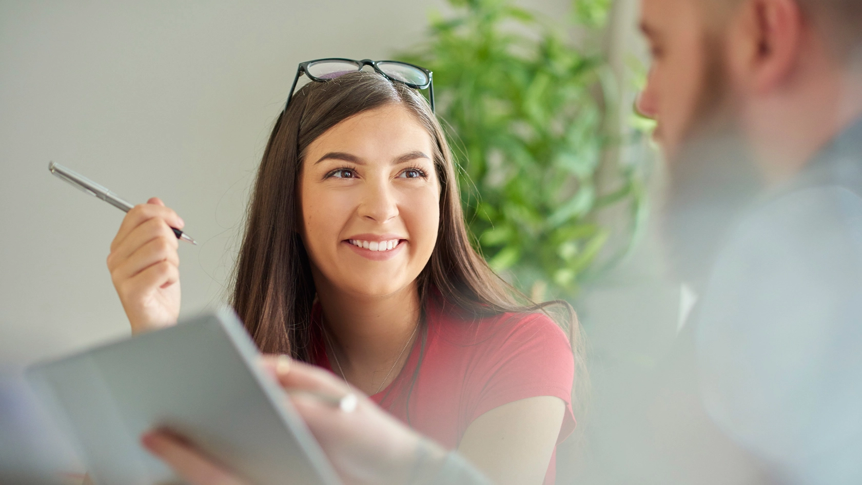Eine junge Frau lernt gemeinsam mit einem jungen Kollegen auf einem Tablet