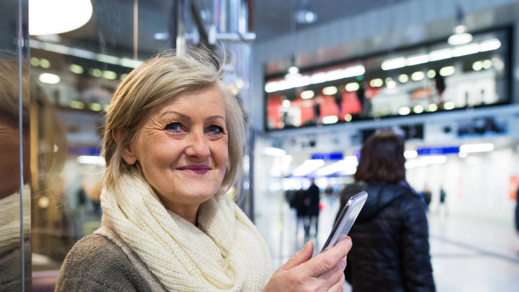 Eine ältere Frau mit einem Smartphone in der Hand.