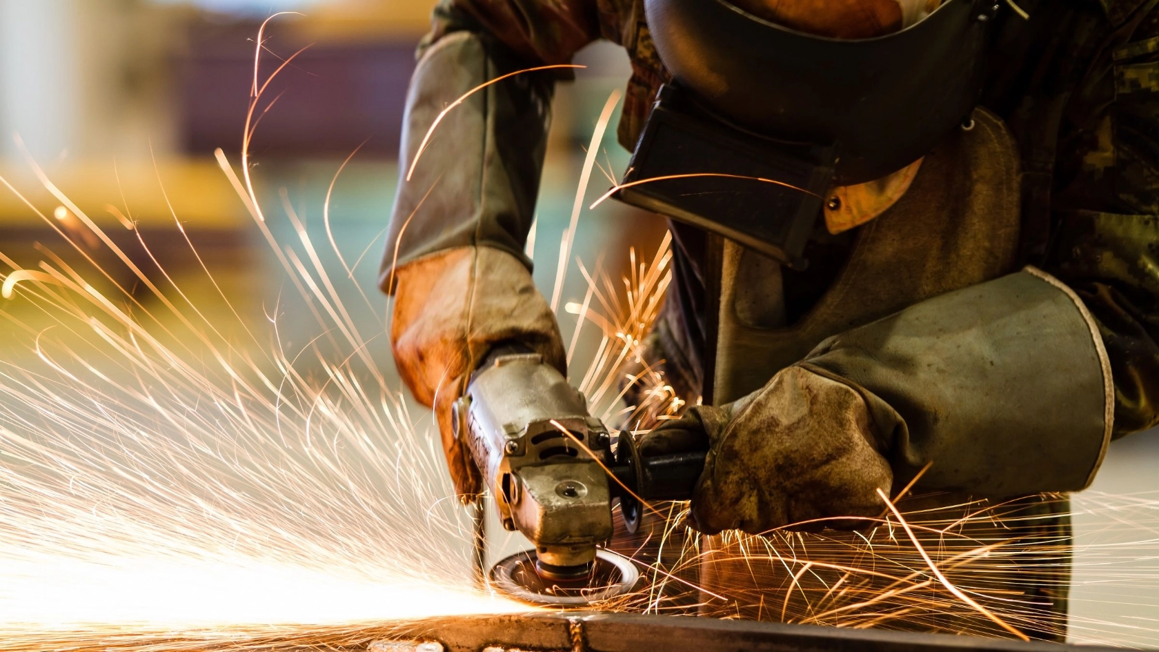 Ein Beschäftigter schleift Metall im Metallhandwerk