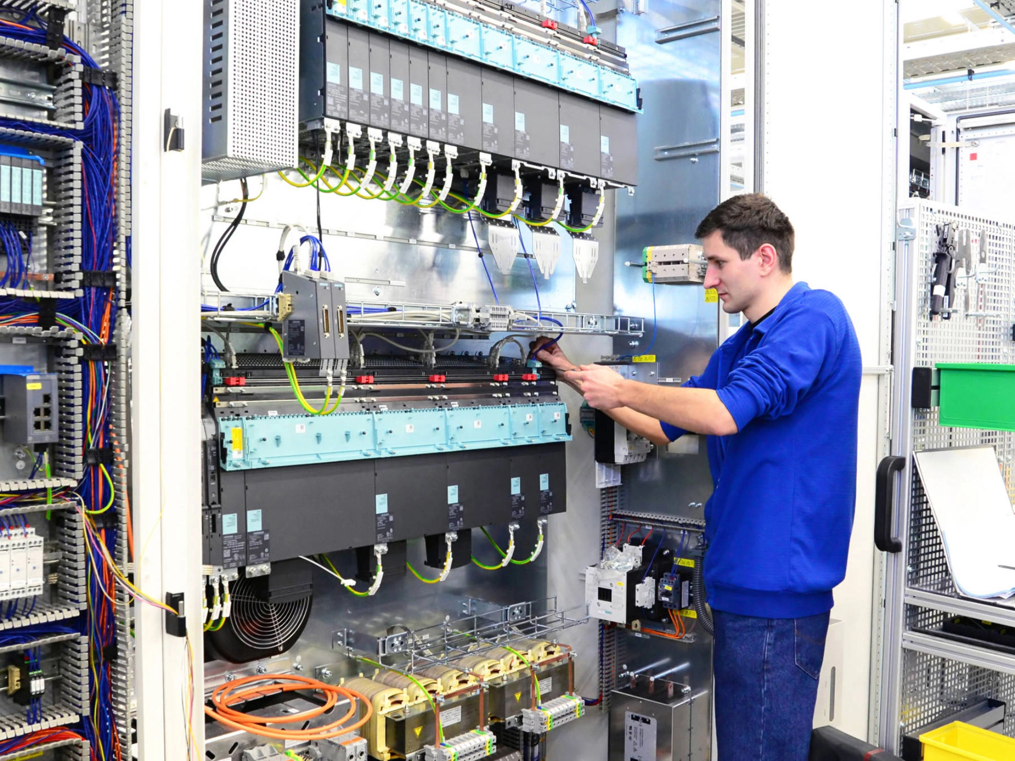Ein junger Mann in der Produktion von Schaltschränken für Industrieanlagen.