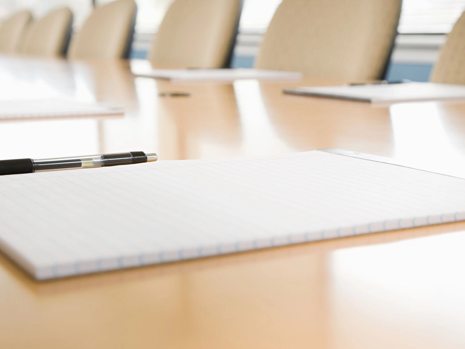 Blöcke und Stifte liegen bereit auf einem unbesetzten Konferenztisch